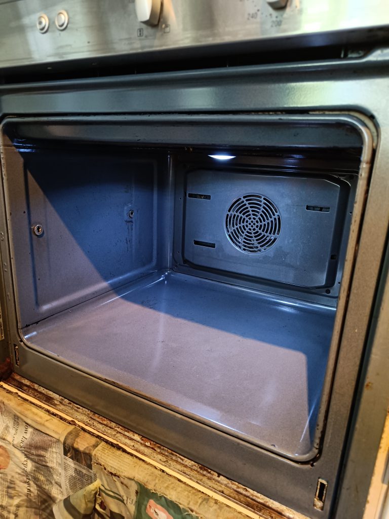 Single oven with removed door after cleaning